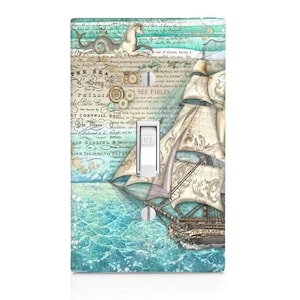May include: A rectangular light switch plate featuring a vintage-style nautical illustration. The design includes a sailing ship on turquoise water, a sea creature, and overlaid text such as The Sea Song and Sea Fables. A white toggle switch is centered.