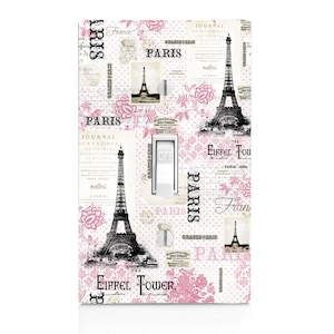 May include: A white light switch cover with a pink and black design featuring the Eiffel Tower, the words "Paris" and "Eiffel Tower", and a repeating pattern of pink flowers and polka dots.