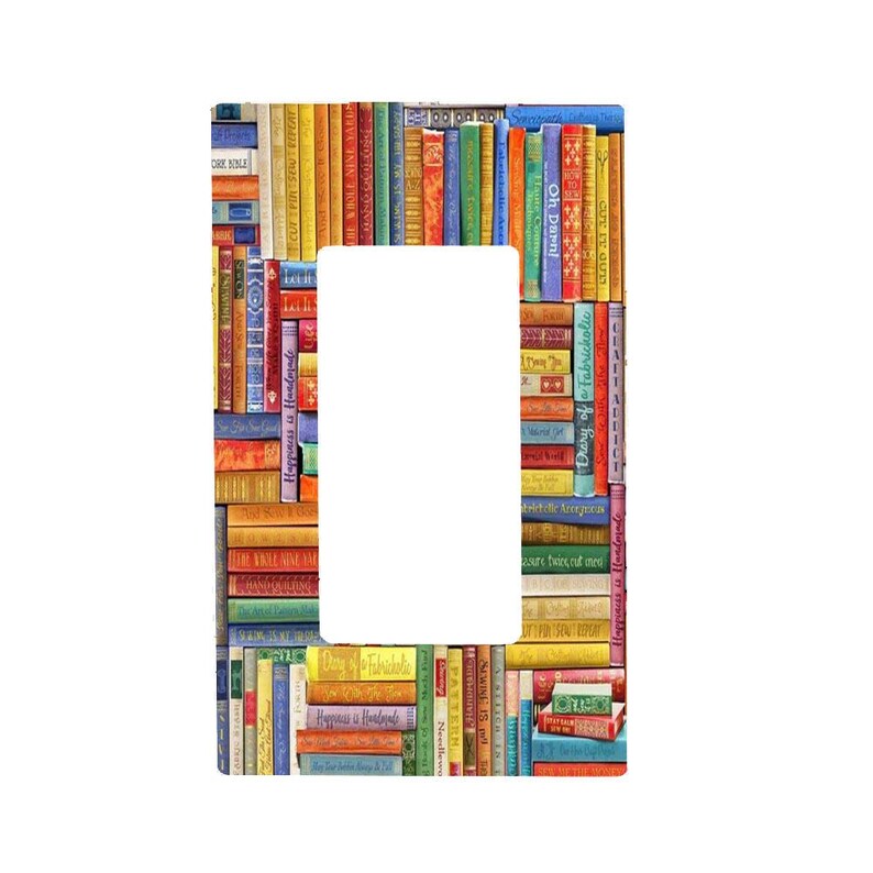 May include: A rectangular light switch cover plate featuring a colourful, multi-directional pattern of stacked book spines. The design includes various shades of red, blue, green, yellow, and orange, with visible text on several spines.