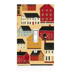 May include: A rectangular light switch cover plate featuring a repeating pattern of various houses and barns in red, yellow, white, and light blue colors against a tan background. A white toggle switch is centered with the word OFF printed on it.