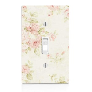 May include: A light switch cover with a floral pattern featuring pink roses on a cream background. The switch is labeled "OFF".