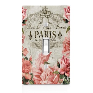May include: Light switch cover with a vintage Parisian design featuring pink roses, a crown, and the text "Marche aux Puces PARIS No. 07, Valles".