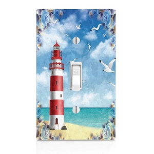 May include: A light switch cover with a watercolor design of a red and white lighthouse on a beach with blue water and seagulls flying overhead. The switch is labeled "OFF".