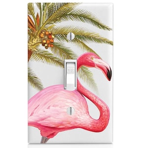 May include: A light switch cover featuring a pink flamingo with a palm tree in the background. The switch is labeled "OFF".