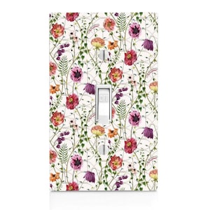 May include: A white light switch cover with a floral pattern. The pattern features pink, red, orange, and purple flowers with green leaves on a white background. The switch cover has the word "OFF" printed on it.