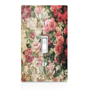 May include: A light switch cover with a vintage floral design featuring pink and red roses on a cream background with a faded script.