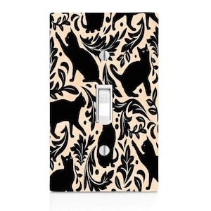 May include: A light switch cover with a black and white pattern of cats and floral designs. The switch is labeled "OFF".