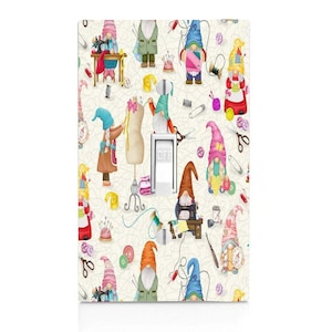 May include: A light switch cover with a whimsical pattern of gnomes sewing, surrounded by colorful thread, buttons, and sewing tools. The text "OFF" is visible on the switch.