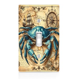 May include: A decorative light switch cover featuring a blue crab design. The crab is centered on a vintage map background with a compass and sailing ship. The switch is in the "OFF" position.