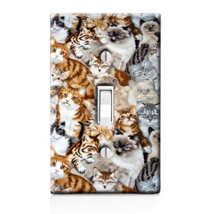 May include: A light switch cover with a colorful pattern of many cats. The switch is labeled "OFF".