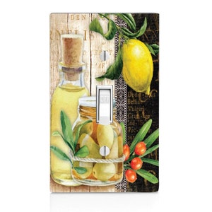 May include: A light switch cover with a watercolor illustration of a jar of olives, a bottle of olive oil, a lemon, and olive branches. The background is a vintage-style print with text in black and white.