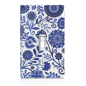 May include: A white light switch cover with a blue and white floral pattern. The switch is labeled "OFF".