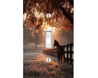 May include: A rectangular light switch cover plate featuring a printed image of a brown horse standing in a frost-covered field next to a dark wooden fence at sunrise, with trees overhead and a white toggle switch in the centre.