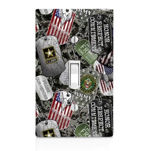 May include: A light switch cover with a camouflage pattern featuring military dog tags with the words "Honor, Respect, Commitment", "Praise Our Heroes", and "U.S. Army".