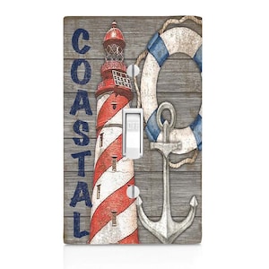 May include: A light switch cover with a nautical theme. It features a red and white striped lighthouse, a blue and white life preserver, and a silver anchor. The word "COASTAL" is written in blue letters on the left side of the cover.