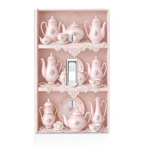 May include: A light switch cover featuring a printed design of a three-tiered pink wooden shelf filled with miniature porcelain tea sets. The tea sets are white with pink floral patterns and gold trim. A central toggle switch is labeled with OFF.
