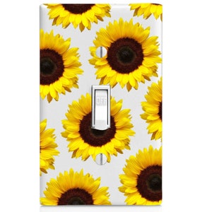 May include: A white light switch cover with a pattern of yellow sunflowers. The switch is labeled "OFF".