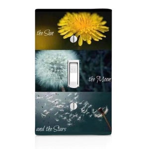 May include: A decorative light switch cover featuring a yellow dandelion, a white dandelion seed head, and dandelion seeds blowing in the wind. The words "the Sun", "the Moon", and "and the Stars" are printed on the cover.