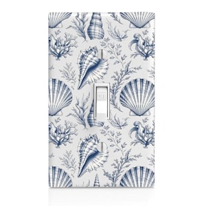 May include: A rectangular light switch wall plate featuring a repeating pattern of blue ink-style illustrations of various seashells, coral, and seaweed on a white background. The plate has a central white toggle switch labeled OFF.