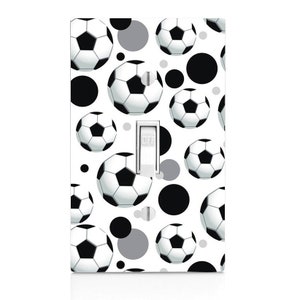 May include: White light switch cover with a pattern of black and gray circles and soccer balls. The switch is labeled "OFF".
