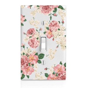May include: A light switch cover with a floral pattern featuring pink and white roses on a light blue background. The switch is labeled "OFF".