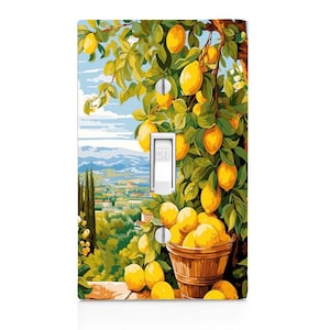 May include: A light switch cover with a painting of a lemon tree with ripe yellow lemons hanging from the branches. The background shows a green landscape with a small town in the distance. The switch is labeled "OFF".