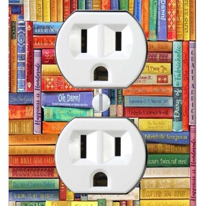 May include: A rectangular wall plate for a double electrical outlet featuring a colourful print of stacked books with sewing-themed titles like Oh Darn, Sew With The Flow, and Happiness is Handmade, with two white plastic sockets.