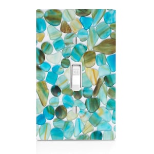 May include: Light switch cover with a design of blue, green, and white sea glass pebbles.