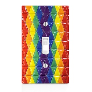 May include: A light switch cover with a rainbow pattern of small triangles. The switch is labeled "OFF".