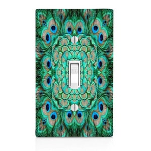 May include: A light switch cover with a peacock feather design. The cover features a mandala-like pattern of blue, green, and brown feathers. The switch is labeled "OFF".