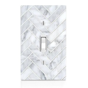 May include: A rectangular light switch cover with a white and gray marble herringbone pattern. The switch is white with the word "OFF" printed on it. Two screw holes are visible.