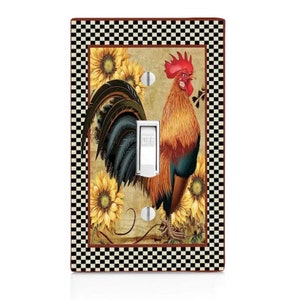 May include: A light switch cover with a black and white checkered border. The center features a rooster with a red comb and a brown, yellow, and blue plumage standing in front of sunflowers. The text "OFF" is on the light switch.