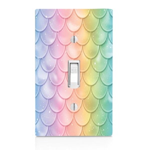 May include: A light switch cover with a rainbow mermaid scale pattern. The cover has a light switch with the word "OFF" printed on it.