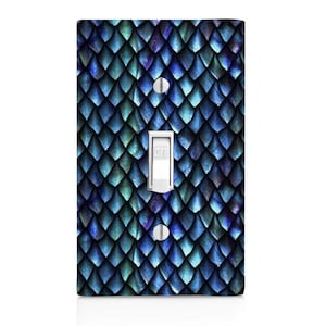 May include: A light switch cover with a blue and green dragon scale pattern. The switch is labeled "OFF".