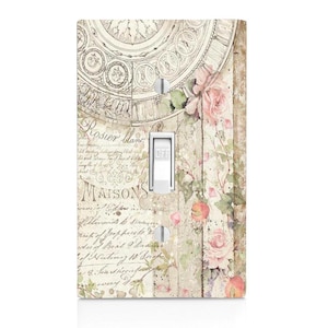 May include: A light switch cover with a vintage floral design. The design features a light pink and white floral pattern with a light brown background. The text "Maisons" is visible on the cover.