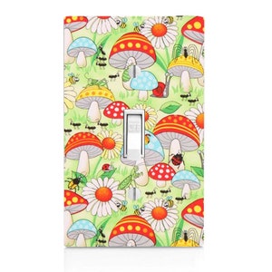 May include: A light switch cover with a colorful design featuring mushrooms, flowers, ladybugs, bees, and ants on a green background. The switch is labeled "OFF".