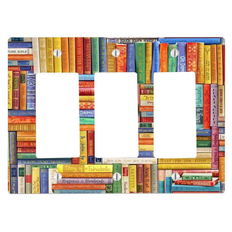 May include: A triple light switch wall plate featuring a colourful, multi-directional pattern of book spines. The design includes various titles such as 'Sew With The Flow', 'Happiness is Handmade', and 'Craft Addict' printed on the spines.