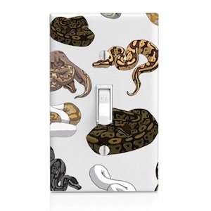May include: A light switch cover with a pattern of brown and white snakes on a white background. The switch is labeled "OFF".