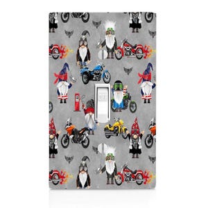 May include: A light switch cover with a repeating pattern of gnomes riding motorcycles. The gnomes are wearing different colored hats and have white beards. The motorcycles are in various colors and styles. The background is a light gray color.