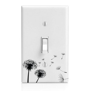 May include: White light switch cover with a black and white dandelion design. The design features a large dandelion in the bottom left corner and several smaller dandelions scattered across the cover. The switch is labeled "OFF".