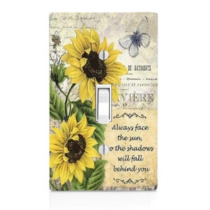 May include: A light switch cover with a vintage floral design featuring sunflowers, a butterfly, and a quote: "Always face the sun, so the shadows will fall behind you".