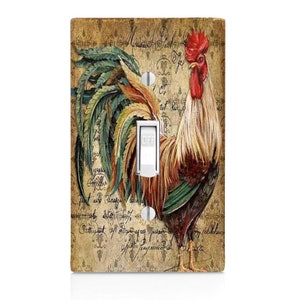 May include: A light switch cover with a vintage design featuring a rooster with a red comb and green, brown, and yellow feathers. The background is a cream color with brown script and a floral pattern.