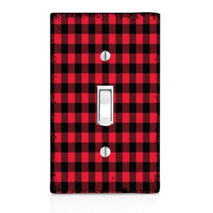 May include: Red and black buffalo plaid light switch cover. The switch cover has a white toggle switch with the word "OFF" printed on it.