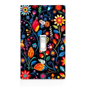 May include: A rectangular light switch wall plate featuring a black background with a vibrant, multi-colored floral pattern. The design includes various stylized flowers, leaves, and swirling vines in shades of red, orange, yellow, blue, and pink. A white toggle switch is centered on the plate.