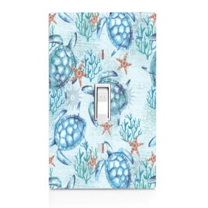 May include: Light blue light switch cover with a watercolor pattern of sea turtles, coral, and starfish. The switch is labeled "OFF".