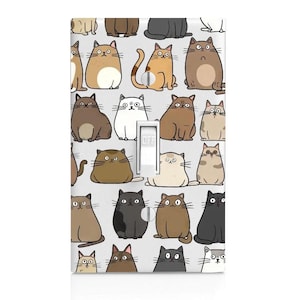 May include: A rectangular light switch wall plate featuring a repeating pattern of various cartoon cats in shades of brown, gray, black, and white against a light gray background. The central toggle switch is white with the word OFF printed on it.