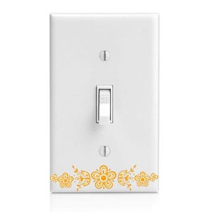 May include: White light switch cover with a decorative floral design in shades of yellow and orange. The switch is in the "OFF" position. The cover has two screws and a rectangular switch.