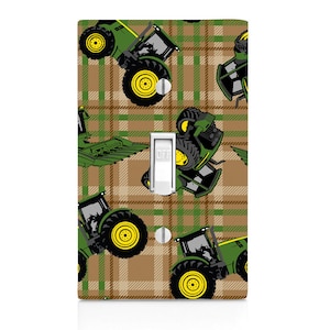 May include: Green and black tractor pattern on a brown and green plaid background. The pattern is designed to fit a light switch cover. The switch is labeled "OFF".
