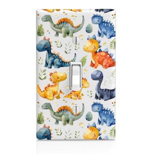 May include: A rectangular light switch cover plate featuring a repeating watercolor pattern of various dinosaurs in shades of blue, green, and orange, interspersed with small green leaves on a white background, with a central white toggle switch.