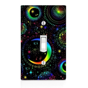 May include: A light switch cover with a colorful design featuring a crescent moon, stars, and fireworks on a black background.